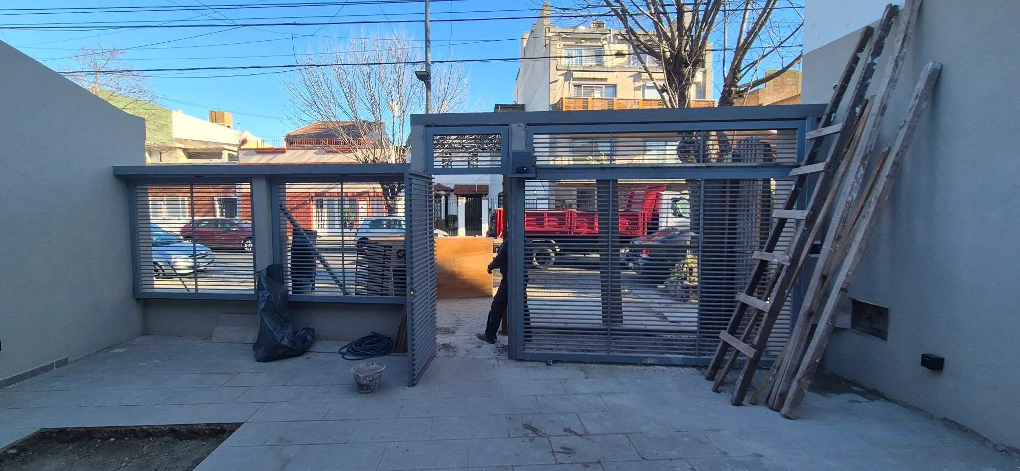 Frente de casa con portón corredizo de hierro y cerco metálico